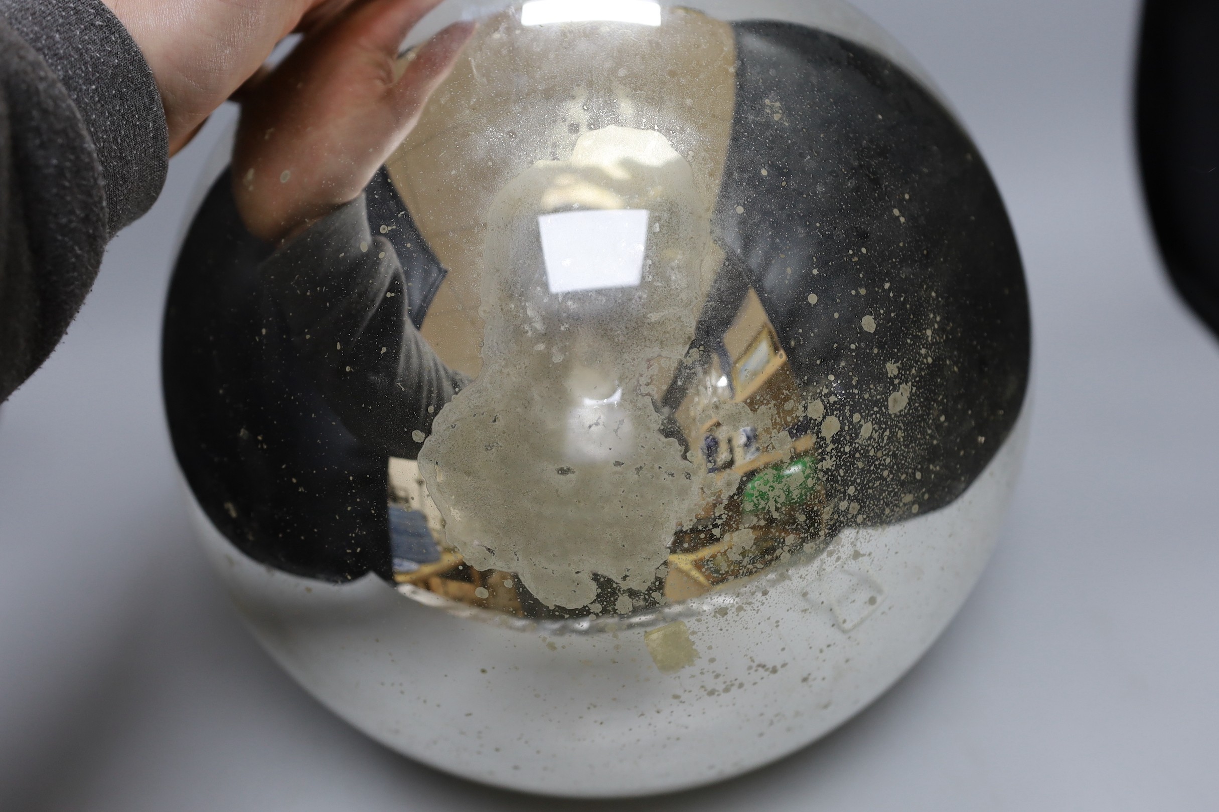 A large silver coloured witch’s ball, 31cm diam.